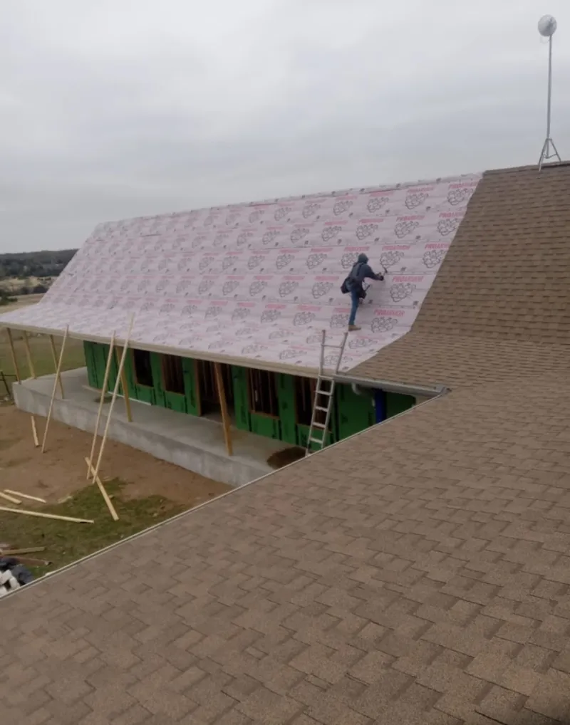 Worker preparing underlayment for a metal roof installation in Silverthorne